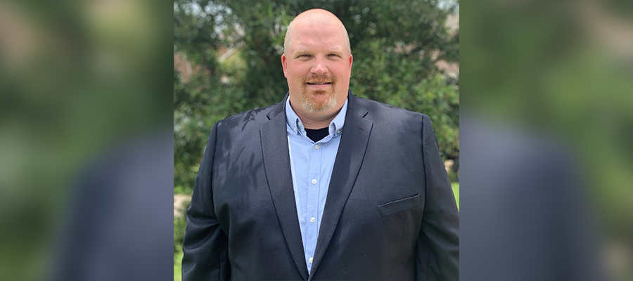 Jerry Staton, Senior Operations Manager at ACRT Services, wearing a dark blazer and light blue shirt, standing outdoors with greenery in the background.