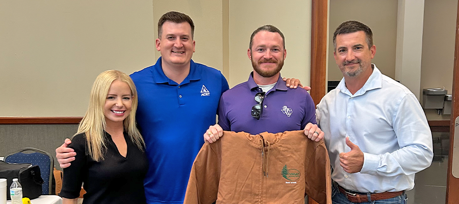 Four ACRT team members smiling at the Vegetation Management Safety Advisory Council Safety Field Day. Safety Super Star recipient Hank Arnold stands in the center holding his award jacket, joined by Adrienne Jones, Eric Morales, and John Kirchner.